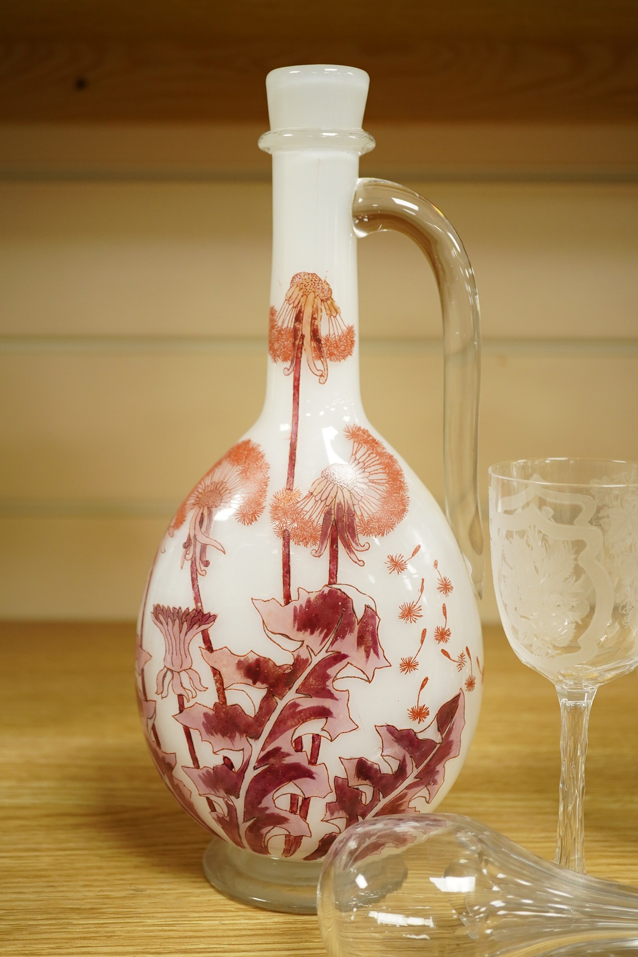 A Continental Art Nouveau glass carafe enamelled with flowers, an English wine glass engraved with the symbols of the Union, a Victorian engraved claret jug and a toddy lifter. Condition - carafe has some occasional scra